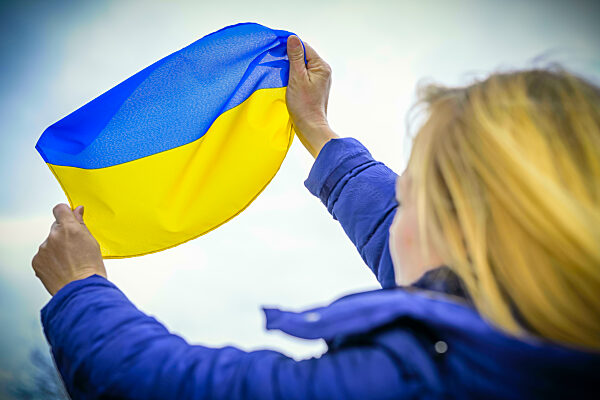 Frau hält die Fahne der Ukraine