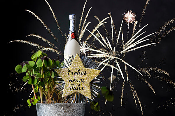 Neujahr und Silvester Gruß zum Jahreswechsel von 2022 auf 2023. Kleeblatt mit Feuerwerk und einem Stern mit Aufschrift: Frohes neues Jahr FOTOMONTAGE