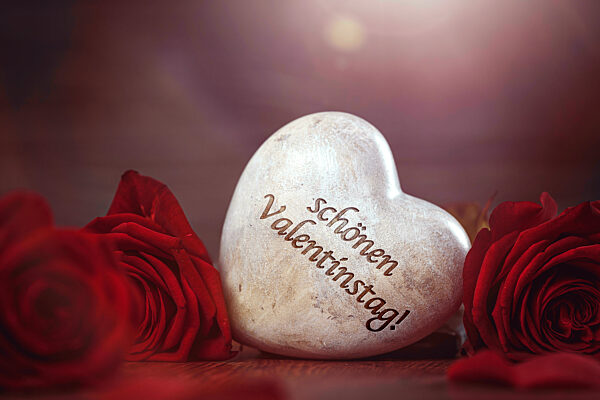 Bavaria, Germany - 12 January 2023: Red Roses And A Heart Made Of Stone With The Inscription: Happy Valentine's Day. February 14 Is Valentine's Day PHOTOMONTAGE