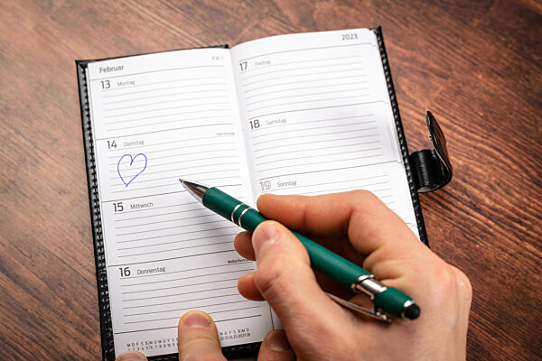 Bavaria, Germany - 25 January 2023: A Man Marks Valentine's Day On February 14 As A Reminder In A Calendar With A Pen