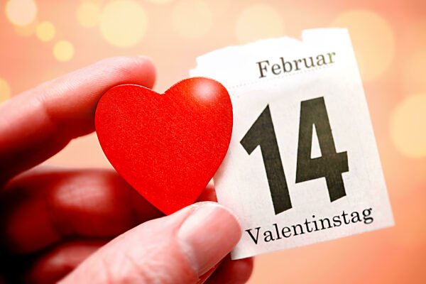 Hand Holding Red Heart And Calendar Page From February 14, Valentine's Day Symbol Photo