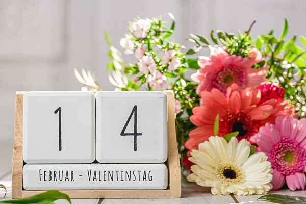 04 March 2023: Bouquet Of Colorful Flowers And Wooden Cubes With The Date 14 February And The Text: February - Valentine's Day PHOTOMONTAGE