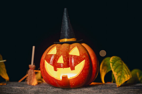 Happy Halloween, Grusel Kürbis leuchtet bei Dunkelheit aus gruseligem Gesicht