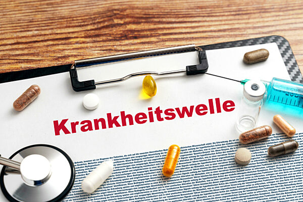 Klemmbrett mit Spritze und Medikamenten und der Aufschrift Krankheitswelle FOTOMONTAGE