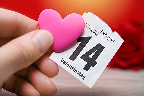 Hand hält Herz und Kalenderblatt mit dem Datum 14. Februar, Symbolfoto Valentinstag