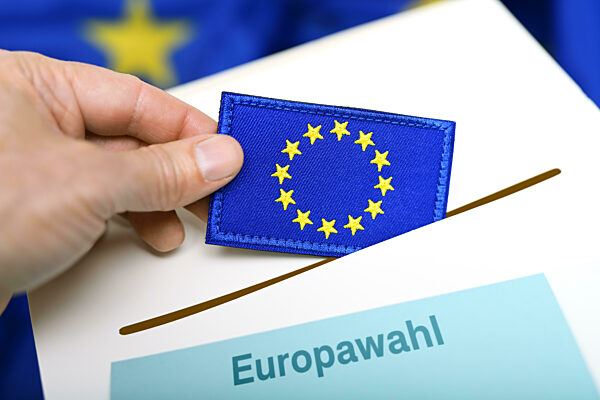 Hand Throws A European Flag Into A Ballot Box, Symbolic Photo European Election, Photomontage