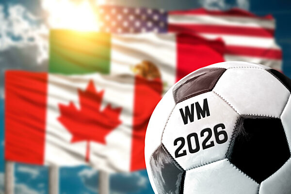 WM 2026, Schriftzug auf einem Fußball vor den Länderflaggen der USA, Mexiko und Kanada. Fußball Weltmeisterschaft 2026 Symbolbild. FOTOMONTAGE