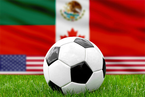 Fußball vor den Länderflaggen der USA, Mexiko und Kanada. Fußball Weltmeisterschaft 2026 Symbolbild. FOTOMONTAGE