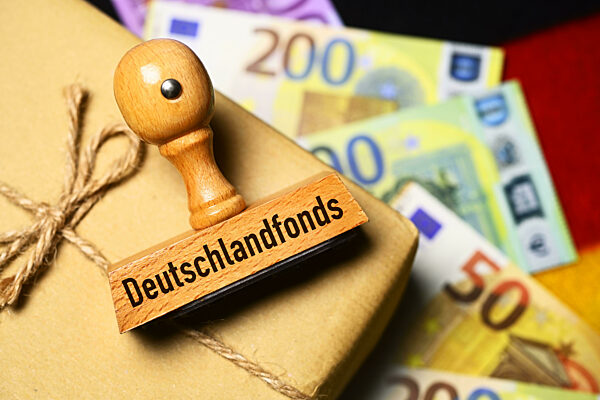 Parcel With Stamp And Inscription Deutschlandfonds On German Flag And Banknotes, Photomontage