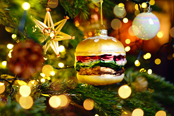 Weihnachtsschmuck in Form eines Hamburgers hängt an einem Weihnachtsbaum