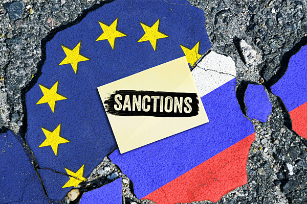 Flags Of The EU And Russia On A Broken Ground And A Note With The Inscription Sanctions, Symbolic Photo For New Sanctions Of The European Union Against Russia, Photomontage