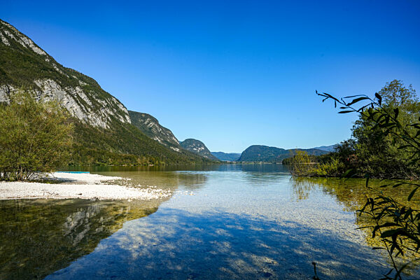 Blick auf den Bohinj-See (Bohinjsko jezero) in Slowenien, umgeben von den Bergen der Julischen Alpen im Triglav-Nationalpark in Slowenien. Strand mit KiesbÃ_nken.