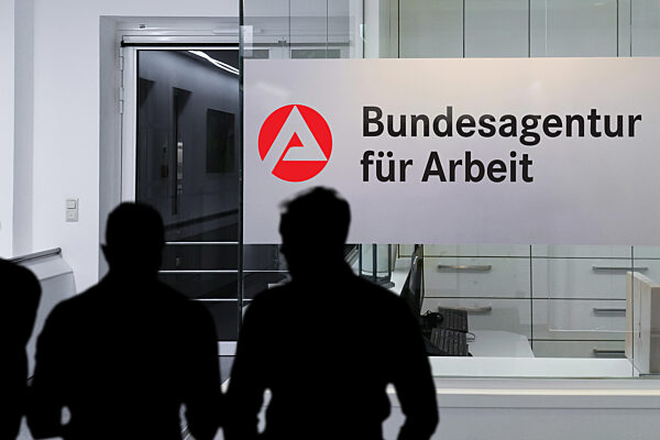 FOTOMONTAGE, Silhouetten von Menschen vor der Bundesagentur für Arbeit. Das Bild symbolisiert Arbeitslosigkeit, staatliche Verwaltung und den Umgang mit Erwerbslosigkeit, Sozialleistungen und arbeitsmarktpolitischen Maßnahmen in Deutschland.