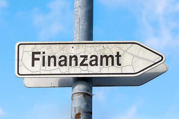 FOTOMONTAGE wegen Retusche, ein Wegweiser zum Finanzamt symbolisiert Steuern und staatliche Finanzverwaltung. Bürger und Unternehmen müssen Steuererklärungen abgeben, Abgaben zahlen und mit Behörden kommunizieren, die Einnahmen prüfen und verwalten.