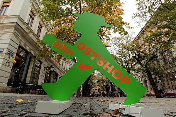 grünes Ampelmännchen der ehemaligen DDR weist den Weg zu einem Ost-Shop mit...