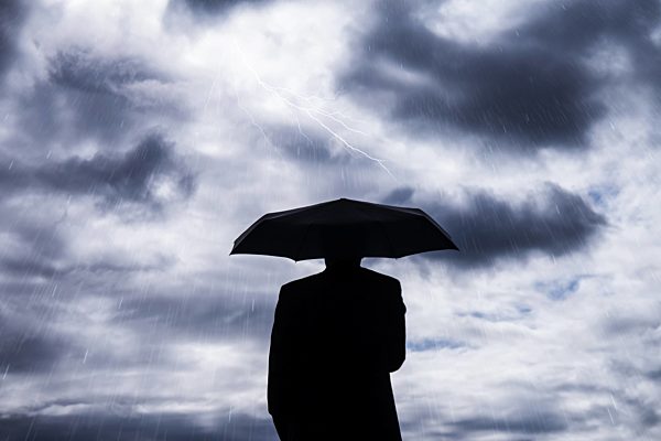 mann mit regenschirm im gewitter