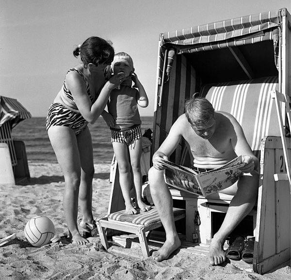 Ein Mann sitz im Strandkorb und liest eine Zeitschrift...