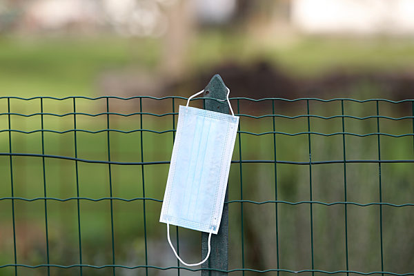 Themenbild - blaue Einwegschutzmaske, Coronamaske, Mundschutz im Freien