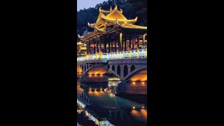 Chinesische Touristenattraktion Feng Huang Ancient Town (Phoenix Ancient Town) Brücke über den Tuo Jiang Fluss bei Nacht beleuchtet. Provinz Hunan, China