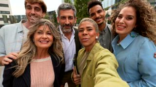 Vielfältige Gruppe glücklicher Unternehmer und Profis, die lächeln und ein Gruppen Selfie mit einem Smartphone in einer modernen Stadt machen und ihren Erfolg und ihre Teamarbeit auf einer Geschäftsreise feiern