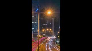 Straßenverkehr in Hongkong im nächtlichen Zeitraffer. Büros, Wolkenkratzer, Gebäude und geschäftiger Verkehr auf der Autobahn mit verschwommenen Autos und Lichtspuren. Hongkong, China