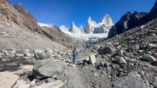 Bergsteigerin auf einem Wanderweg durch traumhafte felsige Berglandschaft, hinten Gletscher und Gipfel des Monte Fitz Roy, Nationalpark Los Glaciares, Patagonien, Santa Cruz Provinz, Argentinien