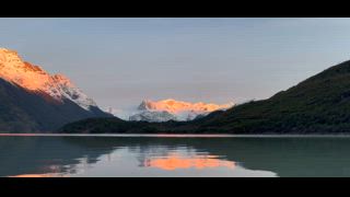 Sonnenaufgang mit Alpenglühen an vergletscherten Berggipfeln am türkisfarbenen See Lago Dickson, O-Trek, Nationalpark Torres del Paine, Patagonien, Chile