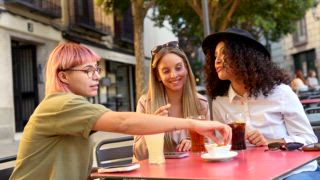 Tourist isst Tapas und trinkt Limonade in einer Bar, die auf einem Tisch auf der Straße sitzt