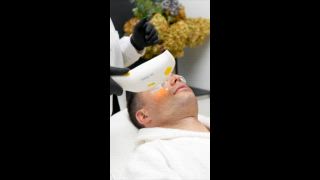 Männlicher Patient, der von einem Dermatologen eine intensive gepulste Lichttherapie erhält. Die Kosmetikerin verwendet moderne Geräte zur Photorejuvenation und behandelt Hautprobleme im Gesicht des Mannes