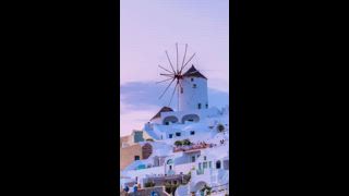 Zeitraffer des berühmten griechischen ikonischen Selfie Spot Touristenziels Oia Village mit traditionellen weißen Häusern und Windmühlen auf der Insel Santorin bei Sonnenuntergang in der Nacht, Griechenland. Effekt „Verkleinern“