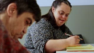 Zwei glückliche Bewohnerinnen mit geistiger Behinderung konzentrierten sich an einem Tisch in einer psychiatrischen Einrichtung auf Zeichen und Malaktivitäten und zeigten Engagement und Konzentration bei Aktivitäten zur kognitiven Entwicklung