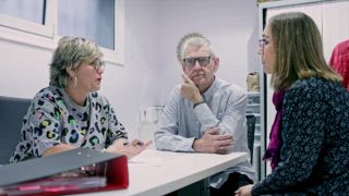 Drei Personen, darunter ein Vorgesetzter, diskutierten in einem unterstützten Lebensumfeld für Menschen mit geistiger Behinderung und förderten so eine unterstützende Routine