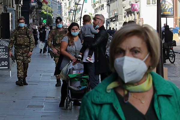 People wearing protective masks walks on the street of the Naples city. The Campania Region is in the red zone with the highest level of restrictions to stop the spread of Covid-19 disease.