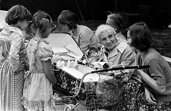 Treffen der Generationen: Eine Mutter sitzt auf einer Parkbank und unterhält...