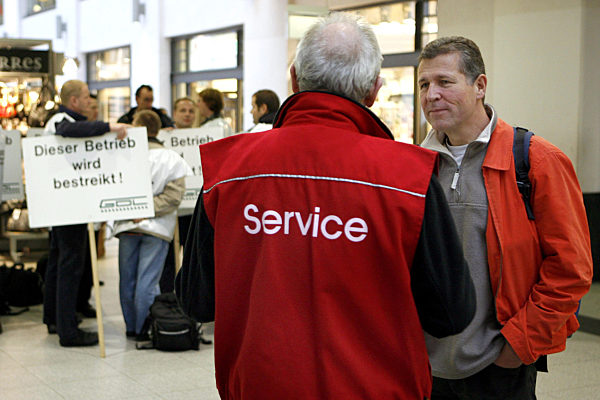 Ein Service-Mitarbeiter der Deutschen Bahn informiert einen Reisenden am...