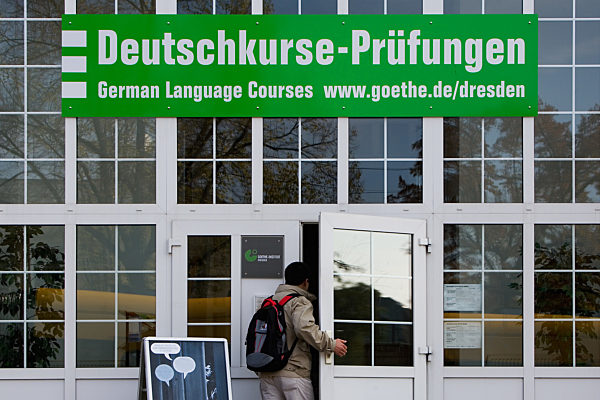 Ein ausländischer Besucher geht durch die Eingangstür am Dresdner...