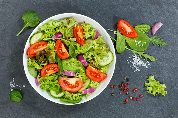Gemischter Salat mit frischen Tomaten gesunde Ernährung Essen von oben auf Schiefertafel