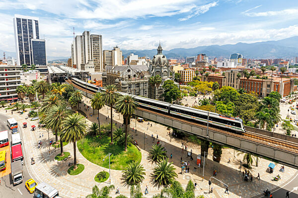 Medellin Skyline mit einem Zug der Metro de Medellín an der Plaza Botero in Medellin, Kolumbien