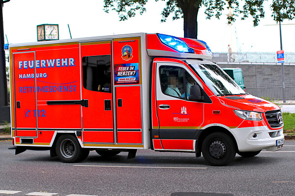 28.06.2023, Hamburg, Ein Krankenwagen der Feuerwehr fährt mit Blaulicht...