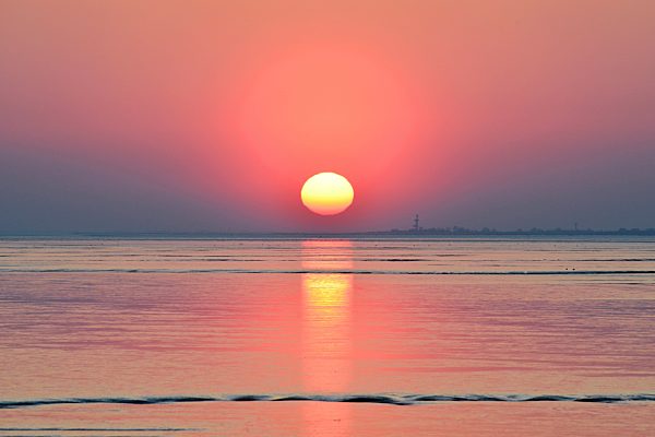 The sun is low and reflecting in the Wadden Sea, Germany