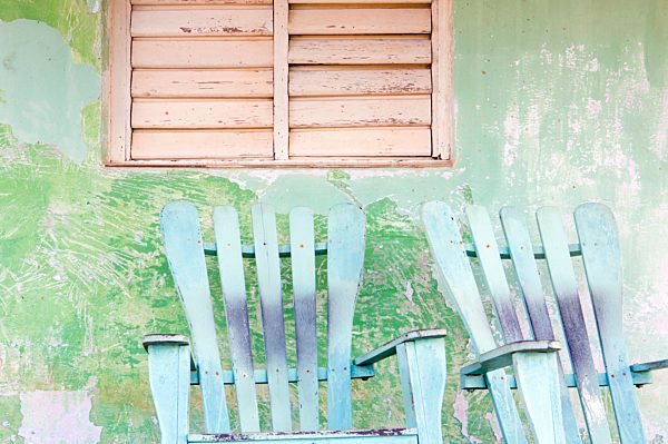 Detail of wall and rocking chair with faded paintwork in green and blue, a common sight in the small town of Vinales, Pinar Del Rio Province, Cuba, West Indies, Central America