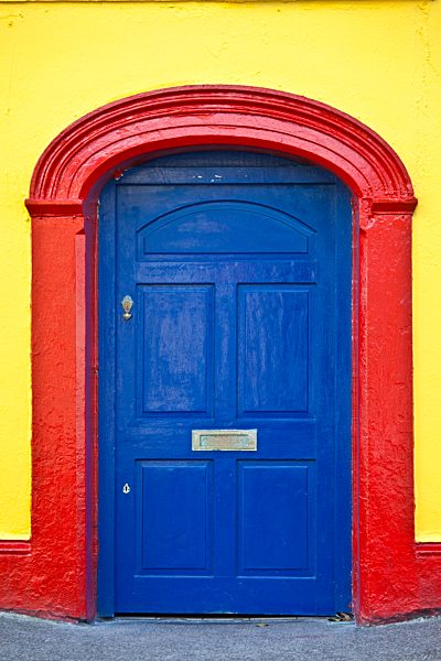 Brightly coloured red blue doorway yellow wall of Furlong's Bar in Passage East, Co. Waterford, Ireland