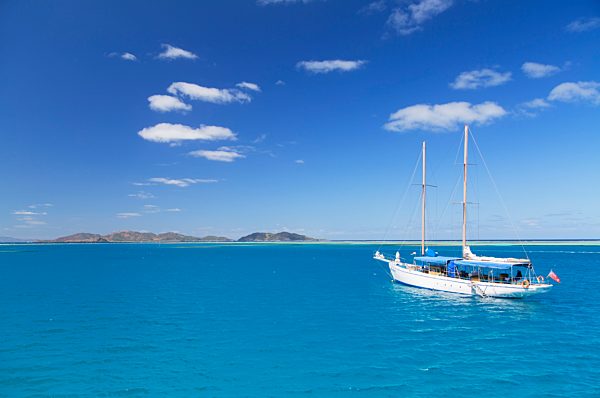 Yacht in lagoon with Malolo Island, Mamanuca Islands, Fiji