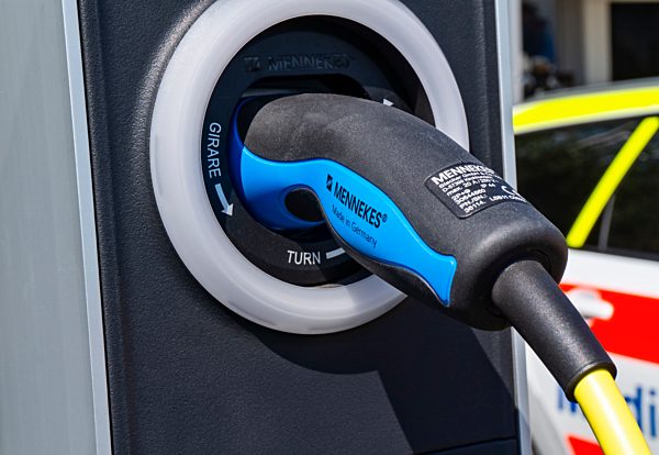 Stecker eines E-Autos mit Ladestation