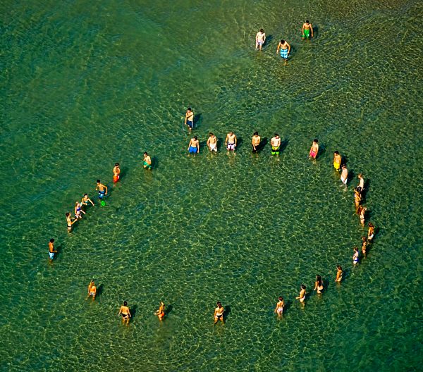 Kreis von Jugendlichen zum Frisbee- Scheibenspiel am Strand von Le Barcarès in Frankreich