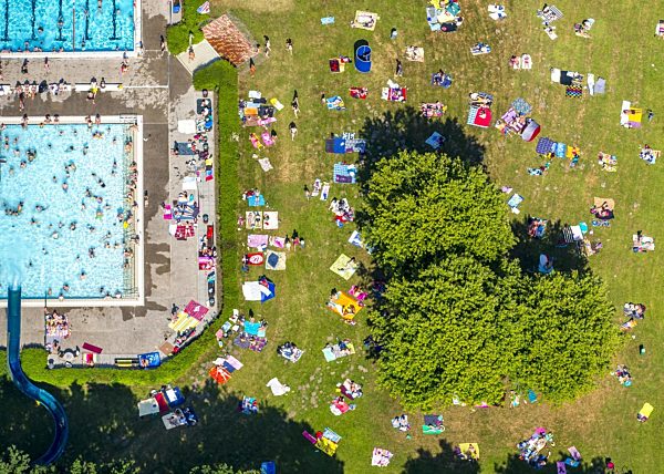 Badegäste auf den Liegewiesen am Schwimmbecken des Freibades Süd in Hamm im Bundesland Nordrhein-Westfalen