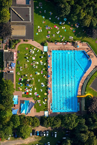 Badegäste auf den Liegewiesen am Schwimmbecken des Freibades in Arnsberg im Bundesland Nordrhein-Westfalen