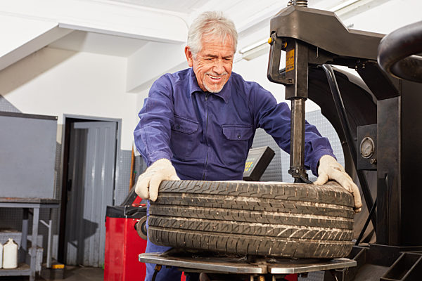 Mechaniker mit Erfahrung beim Reifen aufziehen