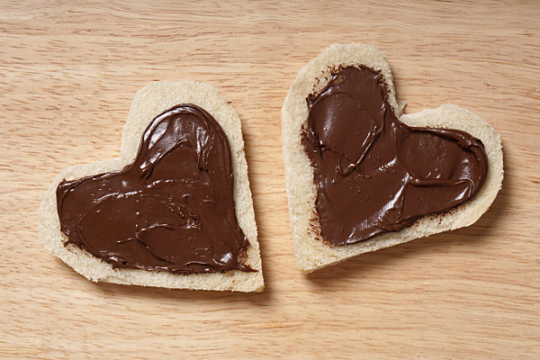 two heart shaped bread slices with chocolate spread