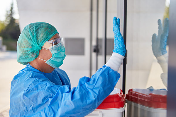 Mediziner bei Organtransport für Operation gibt Zeichen an Klinik Eingang